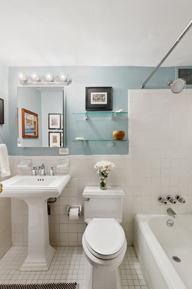 full bathroom featuring tile patterned flooring, a wainscoted wall, toilet, shower / bathing tub combination, and tile walls