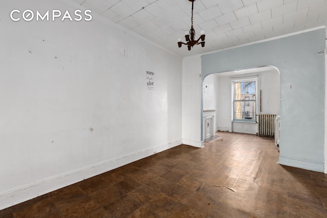 unfurnished dining area featuring baseboards, arched walkways, an inviting chandelier, and ornamental molding