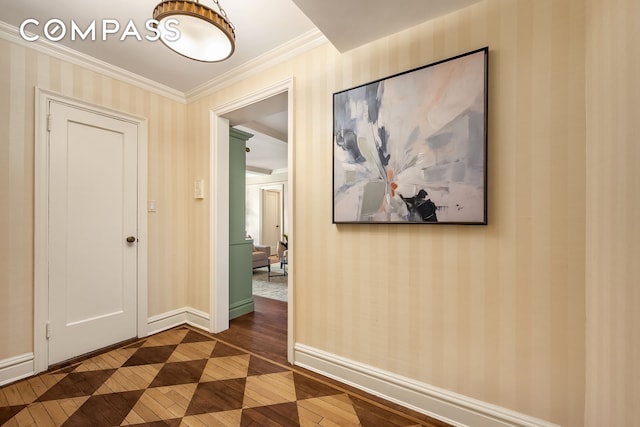 corridor featuring wallpapered walls, ornamental molding, baseboards, and wood-type flooring