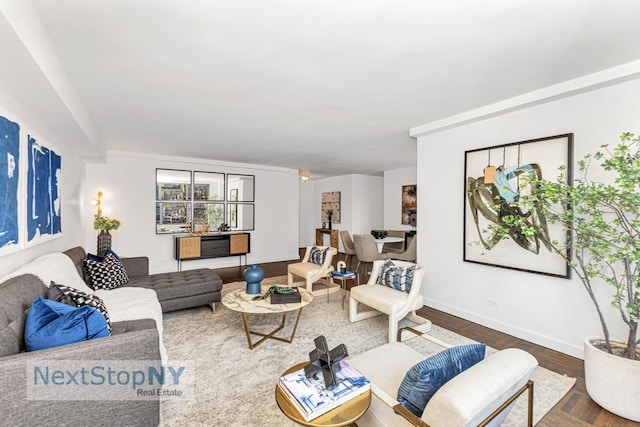 living room featuring dark wood-type flooring and baseboards