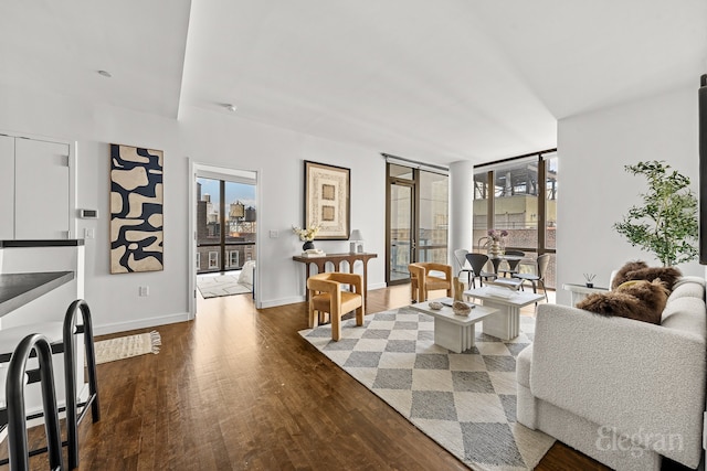 living room with expansive windows, baseboards, and wood finished floors