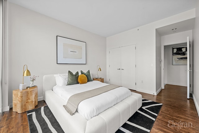 bedroom with a closet, baseboards, and wood finished floors