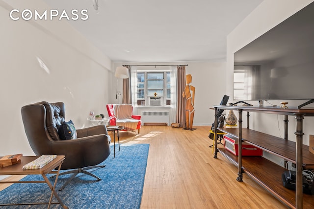 sitting room featuring plenty of natural light, radiator, and wood finished floors