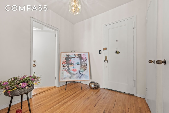 foyer featuring a notable chandelier and wood finished floors