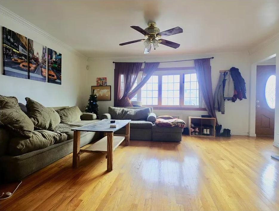 living room featuring light wood-style floors, ceiling fan, and crown molding