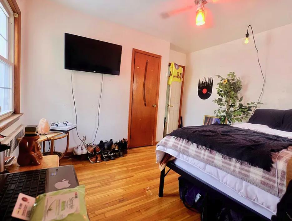 bedroom with light wood-style flooring, radiator, and ceiling fan
