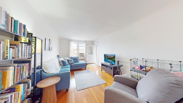living room with ornamental molding and wood finished floors