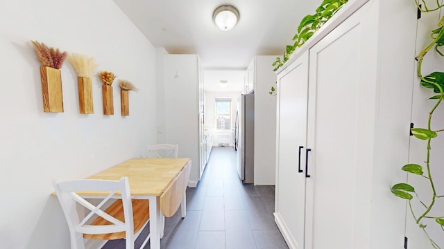 hall with dark tile patterned flooring