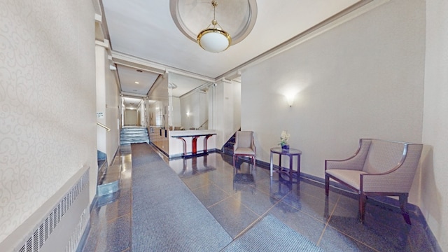 corridor with wallpapered walls, granite floors, baseboards, and a baseboard radiator