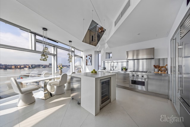 kitchen with stainless steel countertops, a water view, beverage cooler, stainless steel oven, and modern cabinets