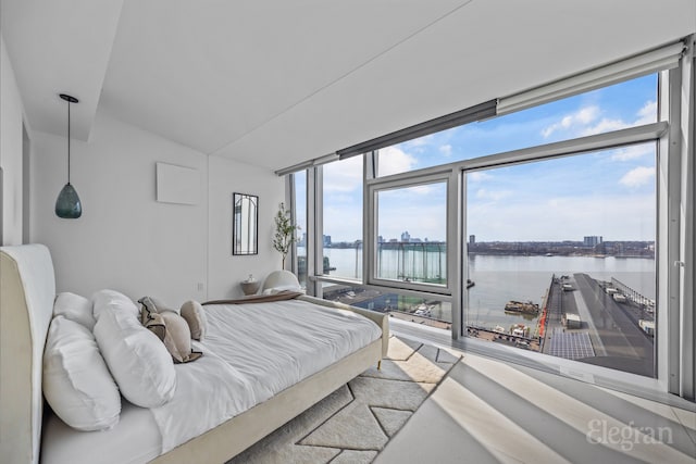 bedroom featuring a water view and lofted ceiling