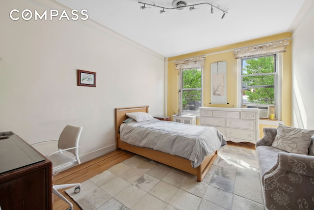 bedroom featuring cooling unit, baseboards, and light wood-style floors