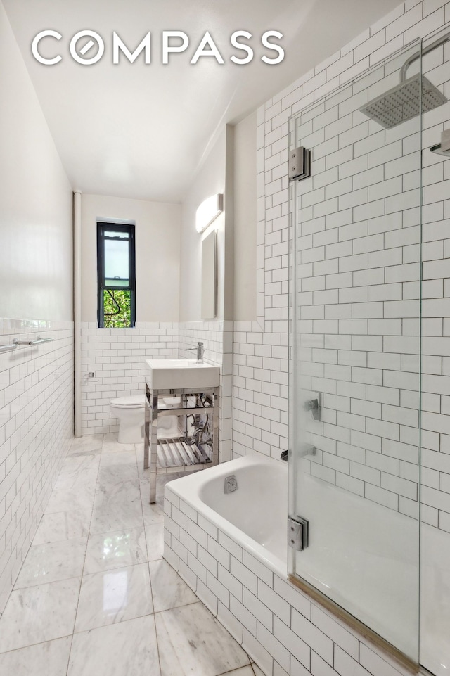 bathroom featuring toilet, tiled shower, tile walls, and tiled tub