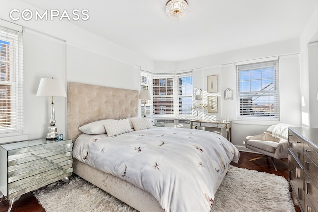 bedroom featuring multiple windows and wood finished floors