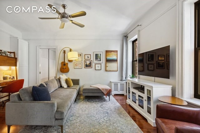 living area with a ceiling fan and dark wood-style flooring