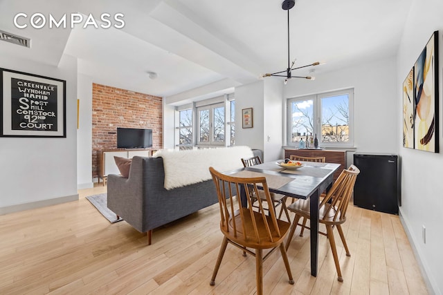 dining room with light wood-style floors, visible vents, and a healthy amount of sunlight