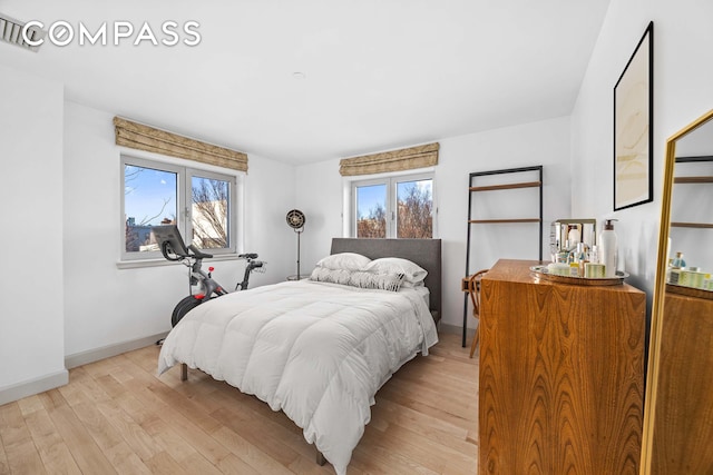 bedroom with light wood finished floors and baseboards