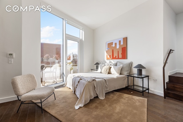 bedroom featuring wood finished floors, baseboards, and access to outside