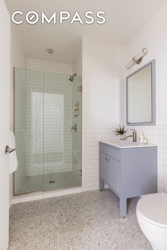 345 Carroll St Unit 4B, New York City, NY 11231 - full bath with tile walls, a shower stall, vanity, toilet, and a wainscoted wall