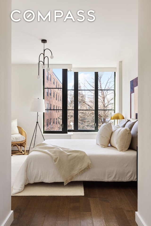 bedroom featuring baseboards and dark wood-style flooring