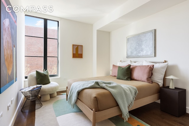 bedroom with dark wood finished floors and baseboards