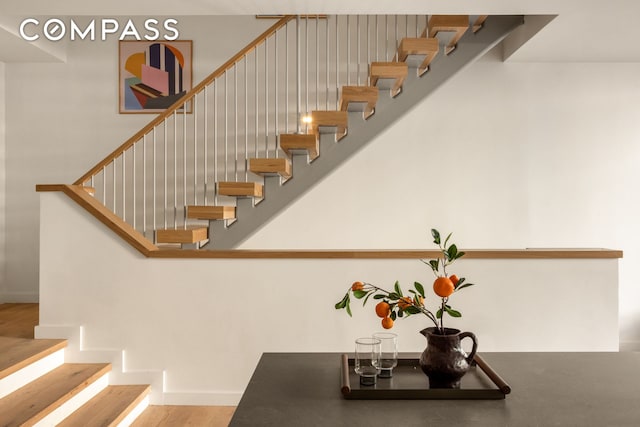 staircase with baseboards and wood finished floors