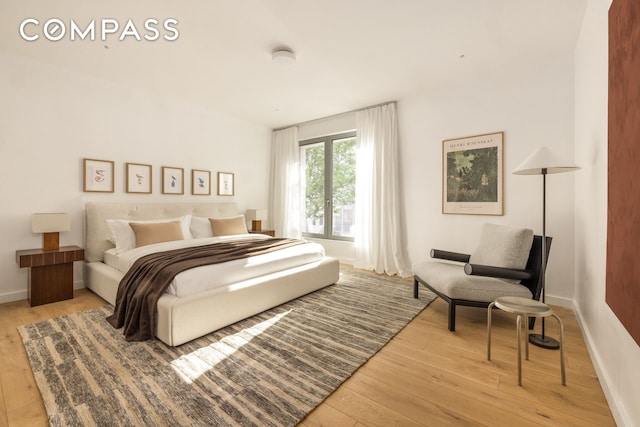 bedroom featuring wood-type flooring and baseboards