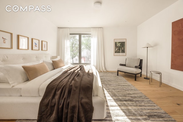 bedroom featuring light wood-style floors and baseboards