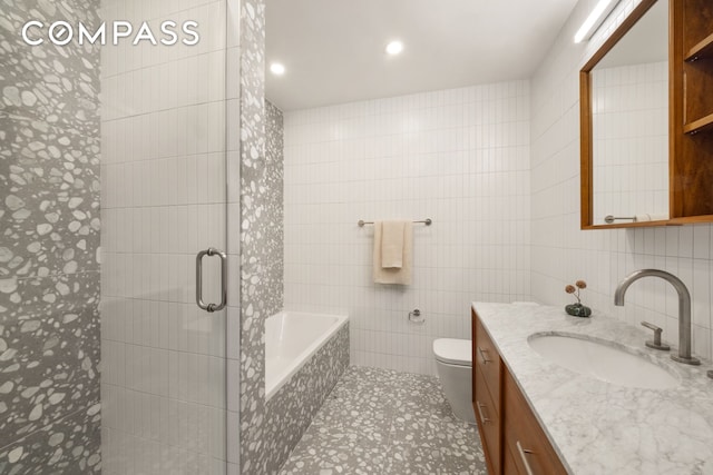 full bathroom featuring tile walls, a tile shower, a garden tub, vanity, and tile patterned floors