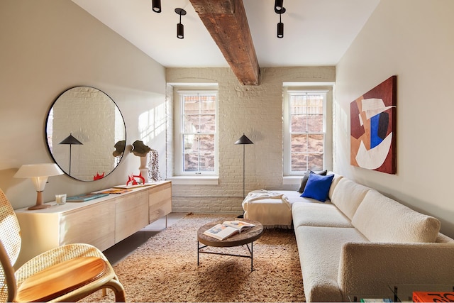 living area featuring brick wall and beamed ceiling