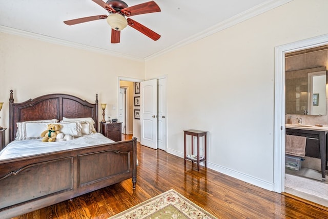 bedroom featuring ornamental molding, a sink, wood finished floors, connected bathroom, and baseboards