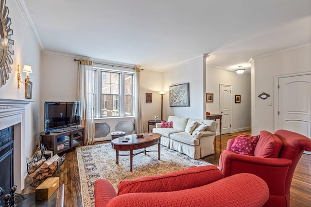 living area with ornamental molding, a fireplace, and wood finished floors