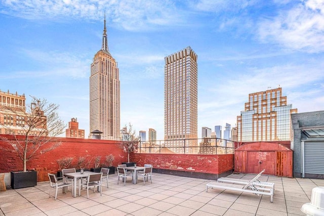 view of patio with outdoor dining space and a view of city