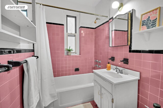full bath featuring vanity, shower / tub combo with curtain, and tile walls