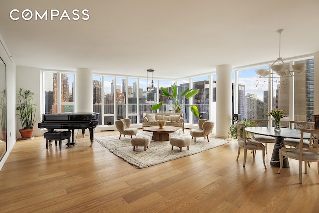 interior space featuring a notable chandelier, a city view, light wood-style flooring, and expansive windows