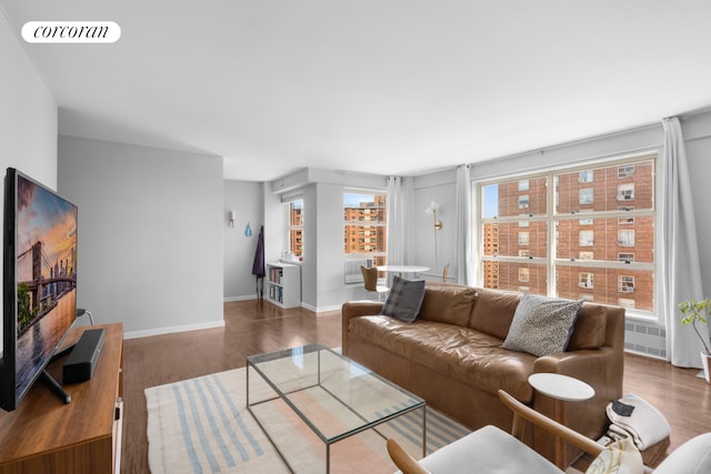 living area with visible vents, baseboards, and wood finished floors