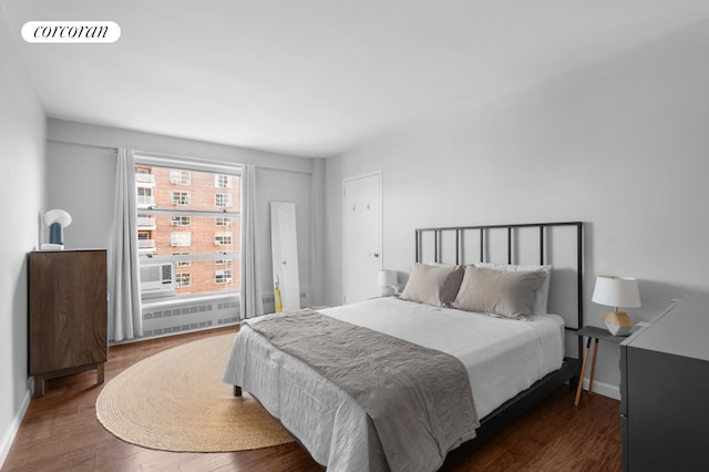 bedroom featuring visible vents, baseboards, and wood finished floors