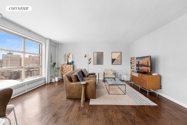 living area featuring visible vents, radiator, a view of city, and wood finished floors