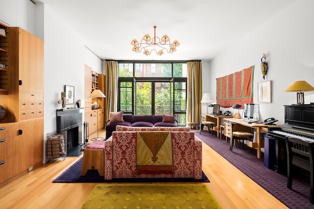 living room with a notable chandelier, expansive windows, and wood finished floors