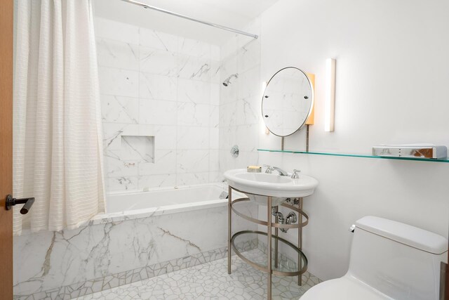 bathroom with toilet, shower / tub combo with curtain, and a sink