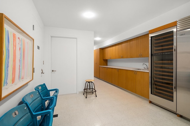 living area featuring wine cooler, light floors, and indoor bar