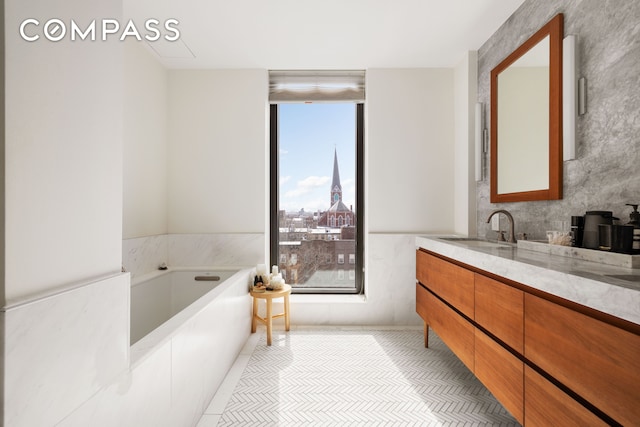 full bath with tile patterned floors, a bath, and vanity