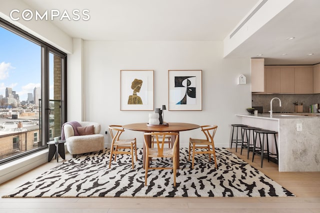 dining area featuring a view of city, wood finished floors, and baseboards