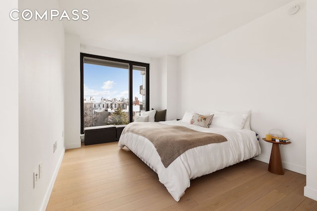 bedroom featuring light wood-type flooring and baseboards