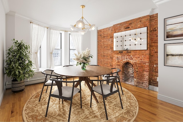 dining area with a notable chandelier, ornamental molding, and brick wall