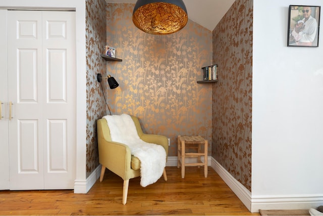 sitting room with wallpapered walls, baseboards, and wood finished floors