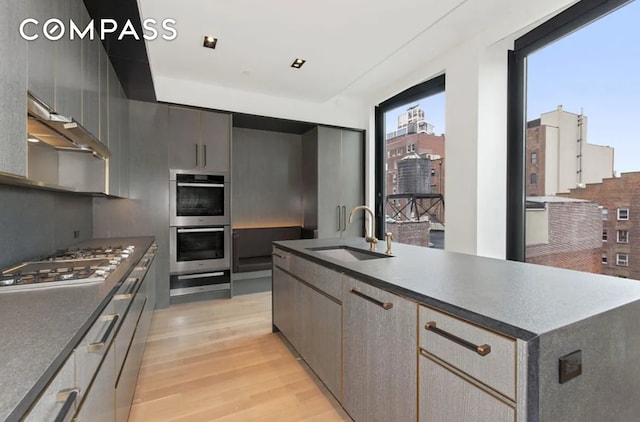 kitchen with a sink, stainless steel appliances, and dark countertops