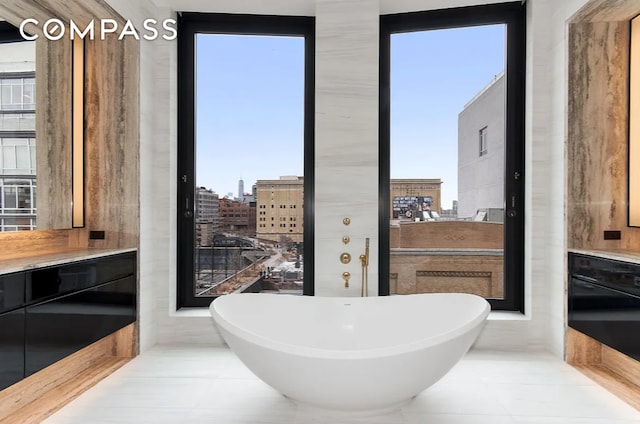 bathroom featuring tile patterned flooring, a view of city, and a freestanding bath