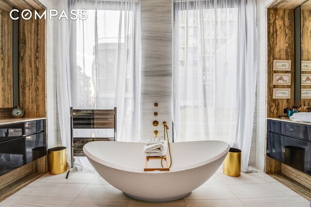 505 W 19th St Unit 7W, New York City, NY 10011 - bathroom featuring a soaking tub, tile patterned floors, radiator heating unit, and vanity