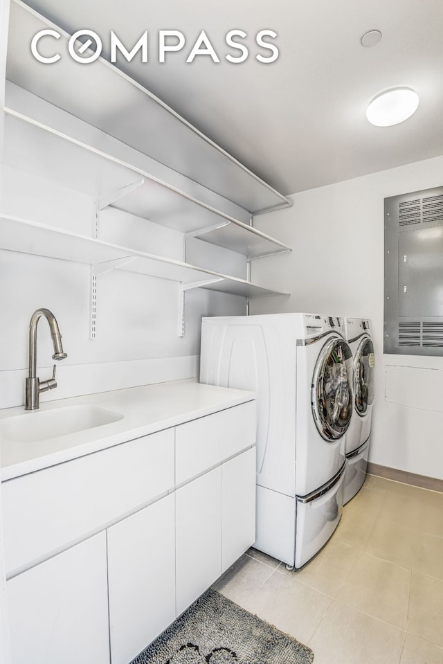 clothes washing area with cabinet space, independent washer and dryer, and a sink